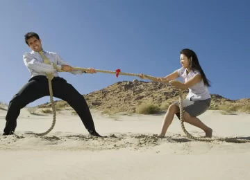 10108384_two-business-people-playing-tug-of-war-in-the-desert