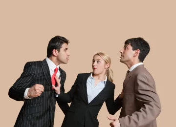 Furious businessmen in conflict with woman trying to resolve over colored background