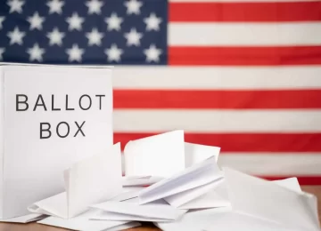 33868524_ballot-box-with-votes-on-table-before-counting-with-us-flag-as-background-concept-of-ballot-or-vote-counting-after-us-election