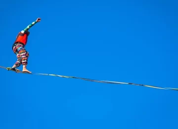 LANZO, ITALY - CIRCA OCTOBER 2020: Slackline athlete during his performance. Concentration, balance and adventure in this dynamic sport.