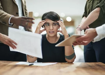 50368198_one-person-can-only-do-so-much-a-young-businesswoman-feeling-overwhelmed-by-her-colleagues-in-the-office