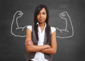 Starke Frau vor Tafel mit aufgemalten Muskeln aus Kreide