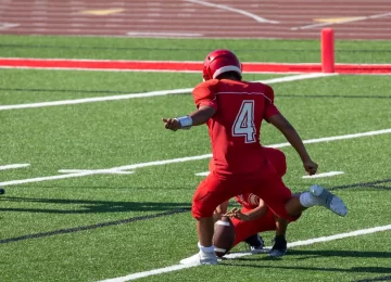 American Football player kicking the ball for the field goal