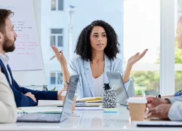 Black woman, leadership and business people in meeting for planning, team strategy or ideas at the office. African American female leader discussing project plan or question for teamwork engagement.